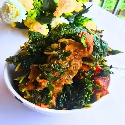 Close-up of Nigerian vegetable stew recipe in a bowl, showing tender goat meat and vibrant greens